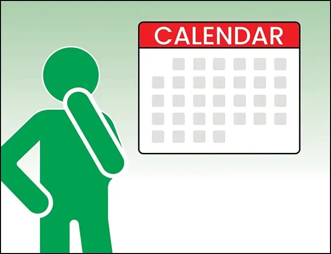 person standing next to calendar with hand on chin