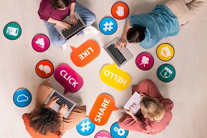 Top view of individuals sitting in a circle among social media activity tags and icons and surfing net on devices.