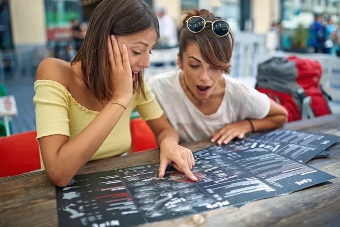 Two friends reading the menu in a cafe together.