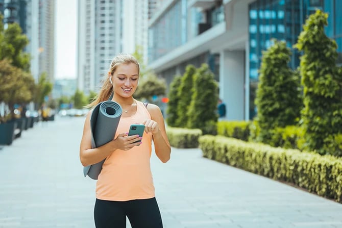 Personal trainer with sport equipment using smartphone.