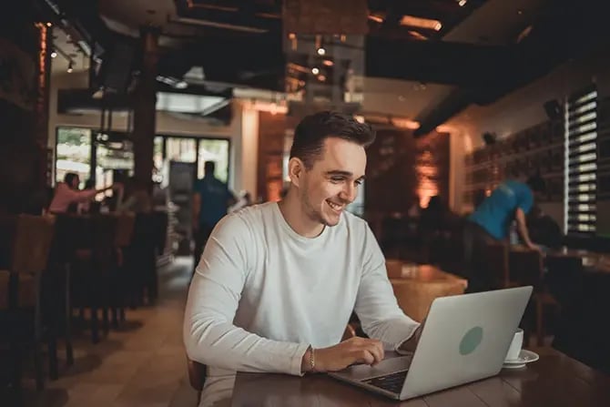 Man on a computer checking analytics of restaurant promotion and social media channels.