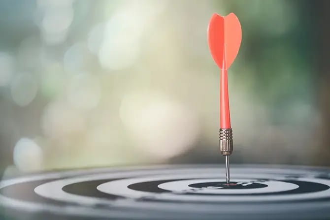 A dart arrow hitting the target center of the dartboard.