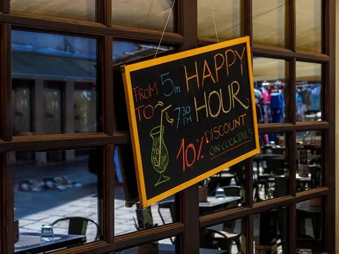Restaurant sign with discount for Happy Hours cocktail.